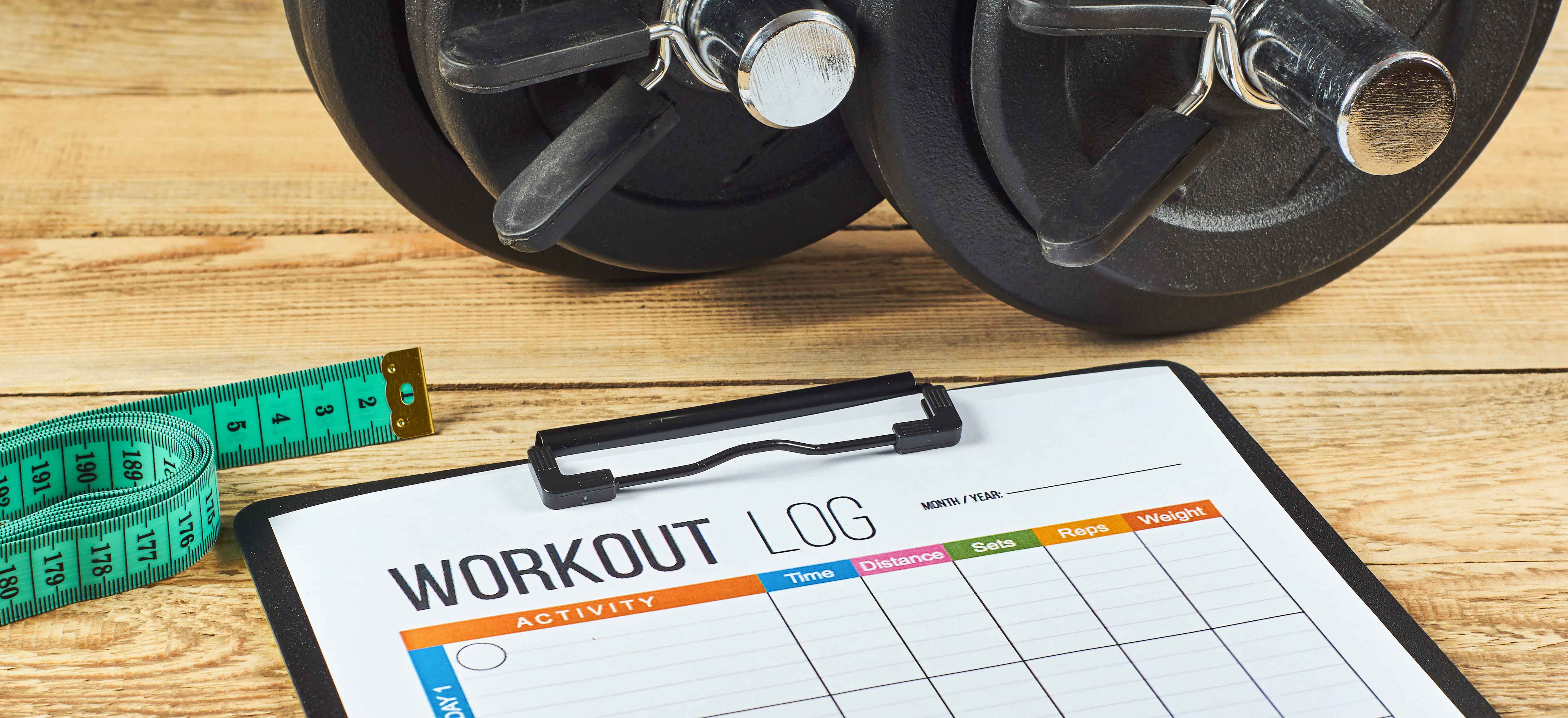 A workout log on a clipboard resting on a table top
